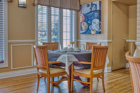 Set dining table beside tall windows