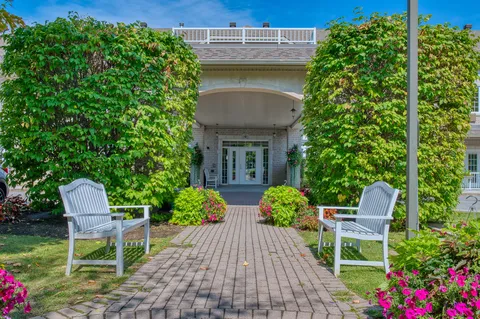 Residence entrance with garden beds and outdoor chairs