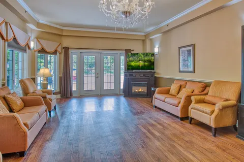 Lounge with sofas, a fireplace and glass patio doors