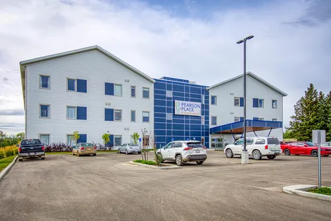 Multi-storey residence and covered entrance beside its front parking area