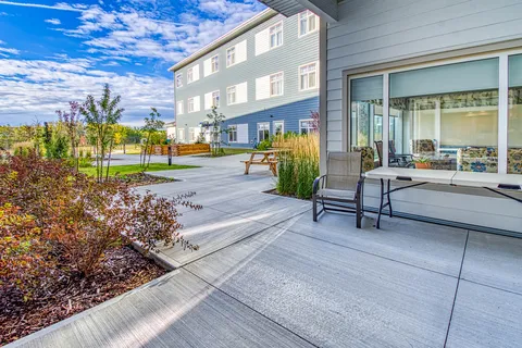 Patio with a table and chairs overlooking garden beds and a courtyard