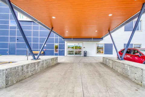 Covered approach to the entrance with an orange ceiling and blue supports