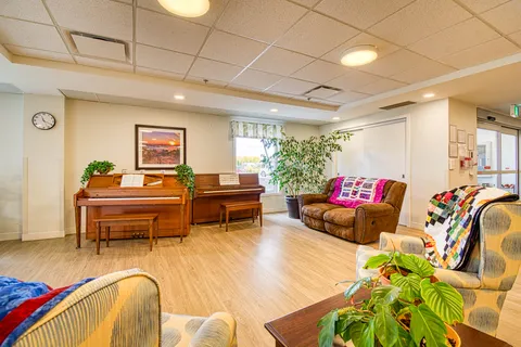 Sitting area with two upright pianos, sofas and armchairs
