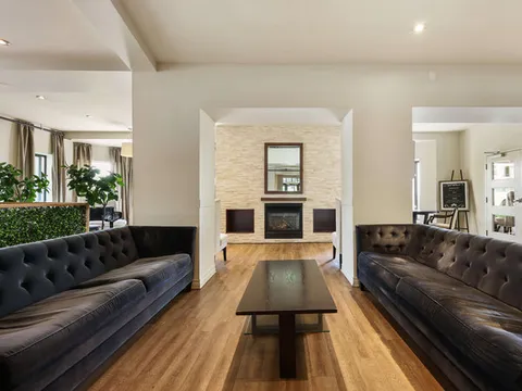Two leather sofas facing a coffee table beside a stone fireplace
