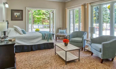 Suite with a bed, sitting area and patio doors.