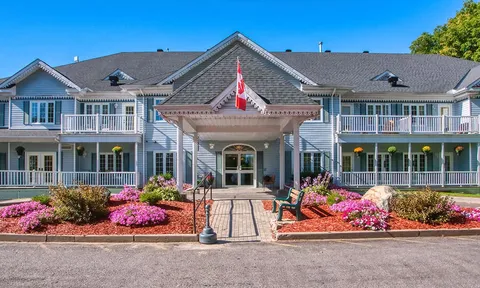 Residence facade with a central entrance and flower beds.