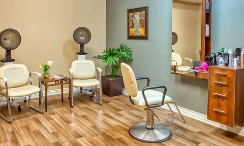 Salon with styling chairs, mirrors and hair dryers.