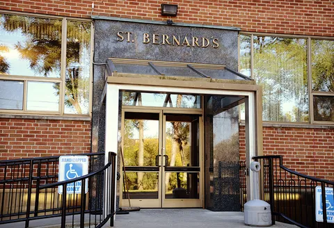 Glass entrance doors beneath a stone sign reading St. Bernards