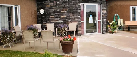 Patio chairs and flower planters beside the residence.