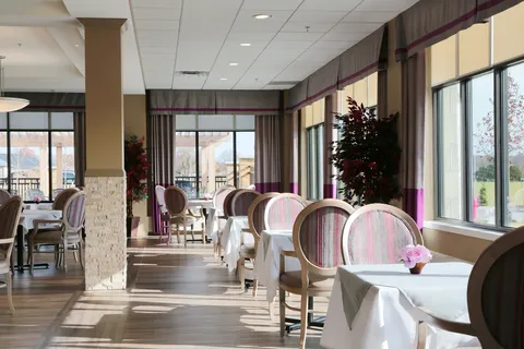 Dining room with tables, upholstered chairs and windows