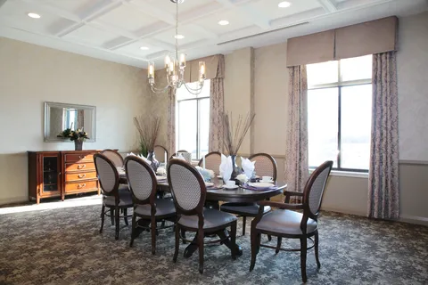 Dining room with a long table, chairs and a wall mirror