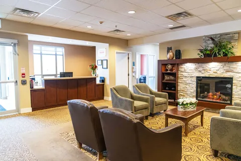 Reception area with armchairs, a coffee table and stone fireplace