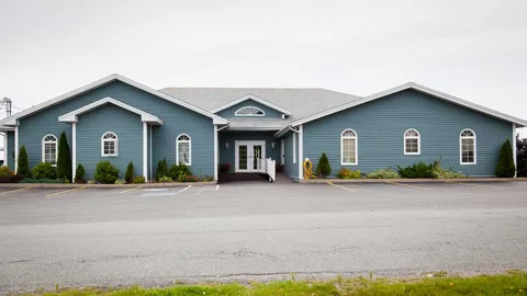 Building exterior with a central entrance and parking area.