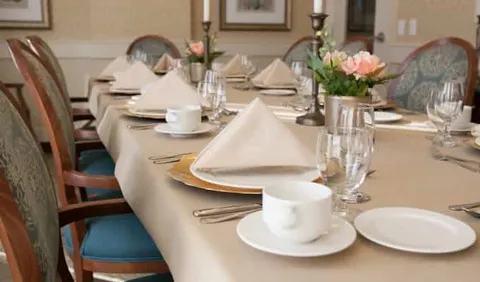 Dining table set with plates, cups, glasses and flowers