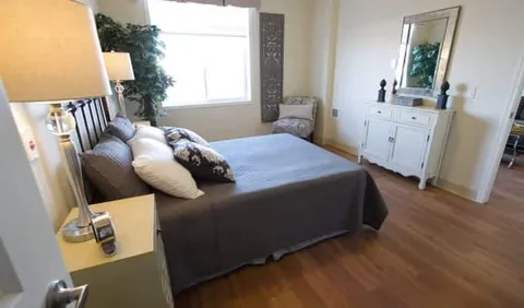 Bedroom with a bed, dresser, mirror and window