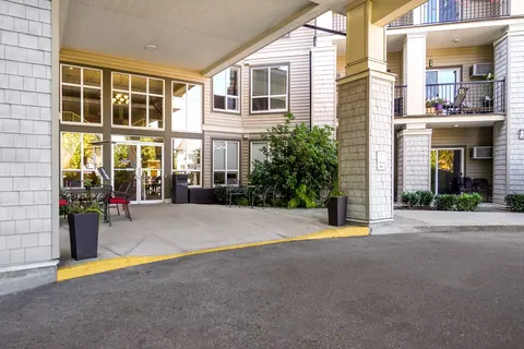 Covered entrance with glass doors, planters and chairs