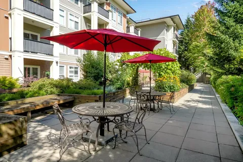 Patio tables and red umbrellas beside the residence