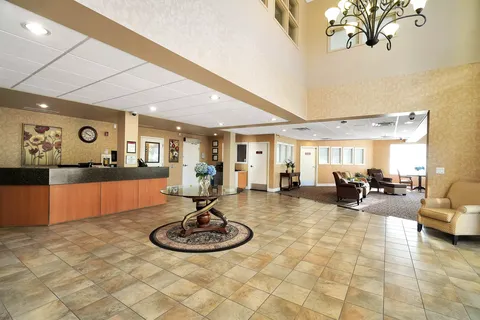 Lobby with a reception counter, tiled floor and armchairs