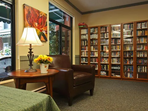 Library with a leather armchair, a table lamp and glass-fronted bookcases