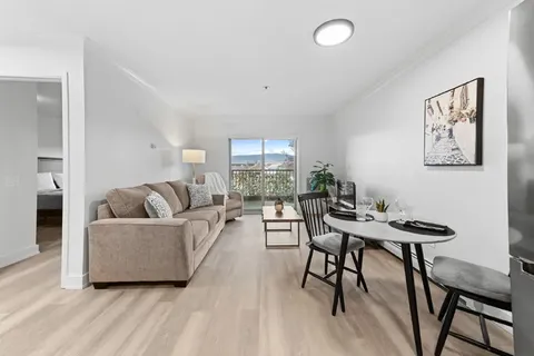Suite living and dining area with a sofa, table and windows.