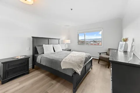 Bedroom with a double bed, bedside cabinets and a window.