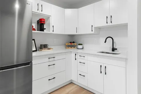 Kitchen with white cabinets, appliances and a sink.