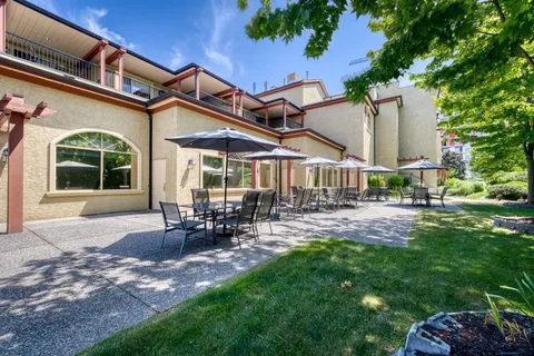 Patio beside the residence with tables, chairs and umbrellas.
