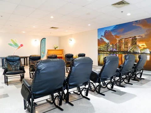 Room with black armchairs, a piano and a large waterfront city mural