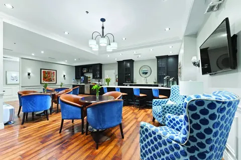 Room with blue chairs, round tables and a counter