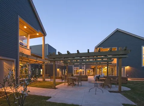 Courtyard with patio tables, chairs and a pergola between residence buildings