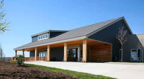 Residence exterior with a broad roof and timber-supported covered entrance
