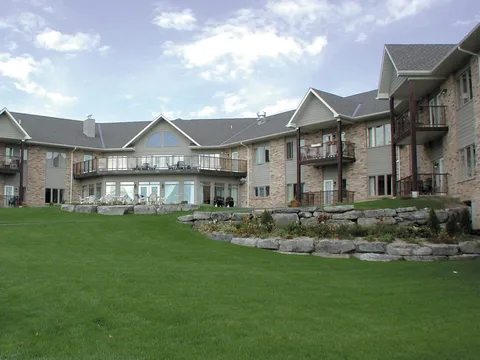 Residence buildings with balconies around a lawn and stone-edged garden