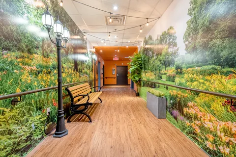 Hallway with garden murals, a wooden bench and decorative street lamps