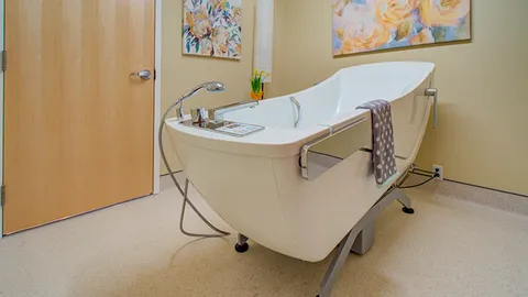 Accessible bathtub with grab rails and a towel rail.
