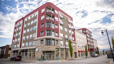 Multi-storey residence at a street corner with balconies and ground-floor windows.