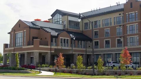 Residence exterior with an entrance canopy, landscaped borders and rooftop terrace.