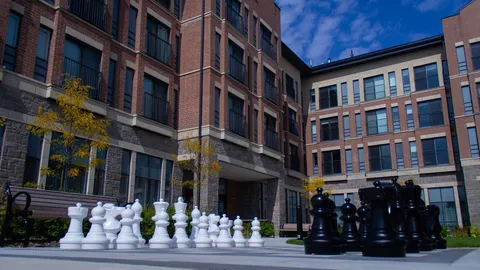 Oversized outdoor chess pieces in the residence courtyard.