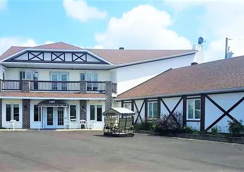 Residence facade with a covered entrance and courtyard seating.