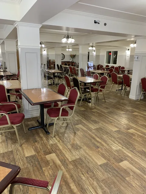 Dining room with red chairs, square tables and white columns