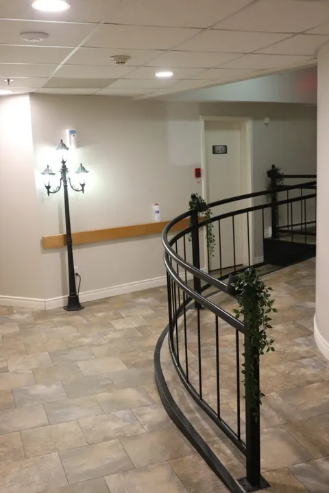 Indoor landing with tiled flooring and a curved black handrail