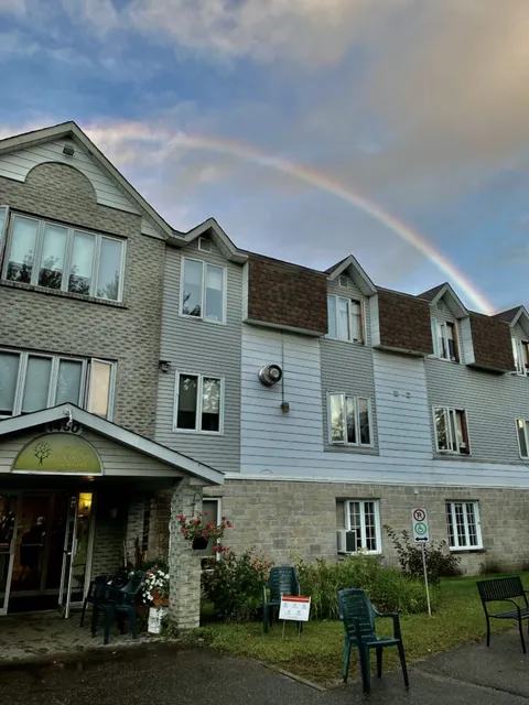 Residence exterior and covered entrance beneath a rainbow