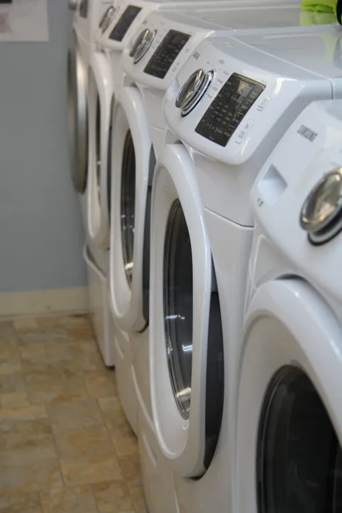 Laundry room with a row of front-loading washing machines
