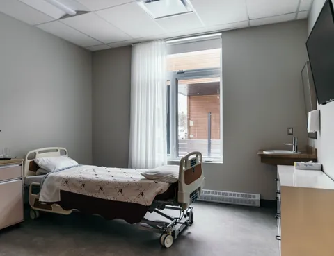 Bedroom with an adjustable bed, a window and a wall-mounted sink
