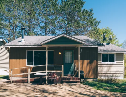 Single-storey brown cottage with a covered porch and an access ramp