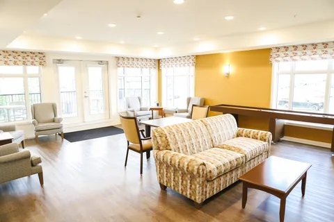 Lounge with sofas, chairs, a coffee table, windows and a patio door.
