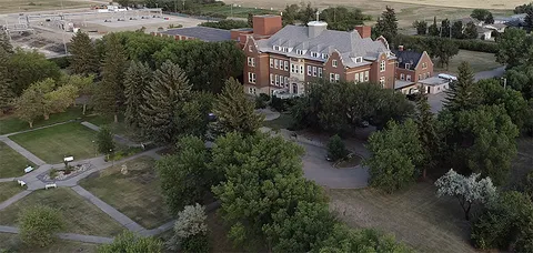 Aerial view of the residence building, driveway and surrounding grounds.