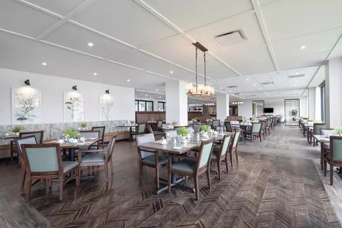 Dining room with set tables, chairs and floral artwork