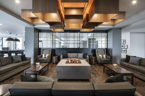 Room with sofas and armchairs around a square fireplace