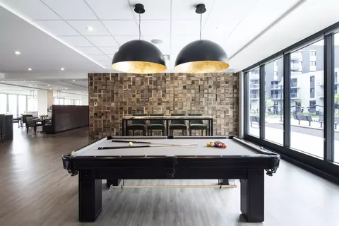 Room with a pool table, counter and stools