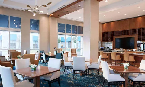 Lounge seating and bar counter beside tall windows